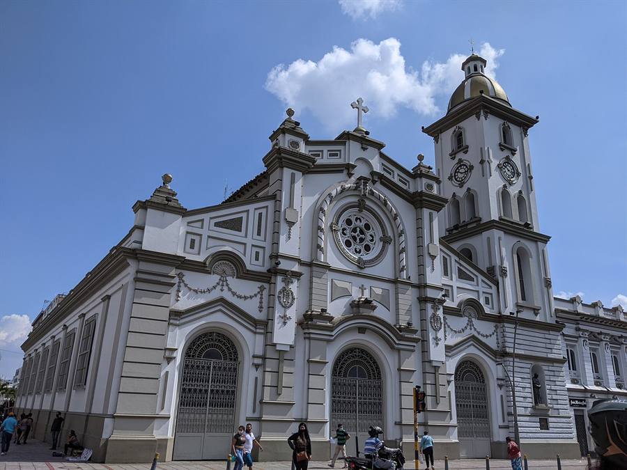 Fachada blanca de la Catedral Primada de Ibagué con su torre y cielo azul.